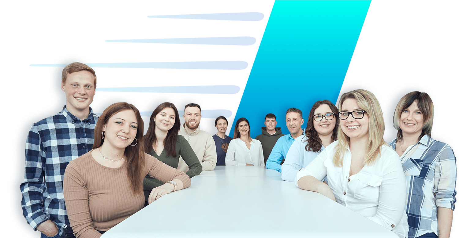 Viele Mitarbeiter stehen um einen Tisch versammelt und schauen nach vorne